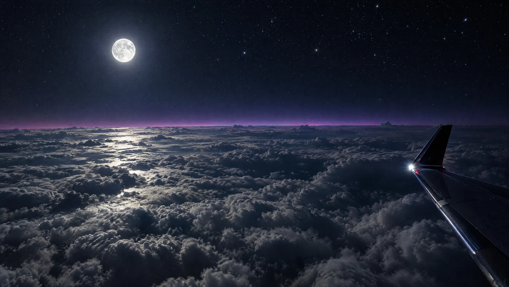 Moonlit clouds seen from a jet wingtip